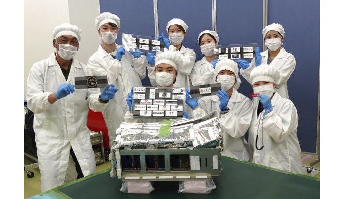 JAXAの筑波宇宙センターにて。衛星放出ケースへの収納作業を完了した奥山研究室のメンバー（写真提供：JAXA）