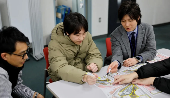 穴澤先生（左）や職員と一緒に飛行計画を確認